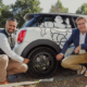 Anish K. Taneja (links), CEO der Michelin-Region Nordeuropa, sowie Cyrille Roget, Scientific & Communication Director bei dem Reifenhersteller, präsentieren den Luftlosreifen UPTIS in seinem natürlichen Umfeld: auf den öffentlichen Straßen Münchens (Bild: Michelin)