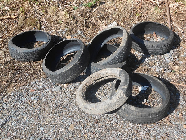Zwei Umweltfrevler sollen in einem Wald in Hohenlimburg zunächst Pkw-Reifen von den Felgen – so wie es aussieht per Flex – abtrennt haben, nur um sie anschließen dann einfach dort liegen zu lassen (Bild: Polizei Hagen)